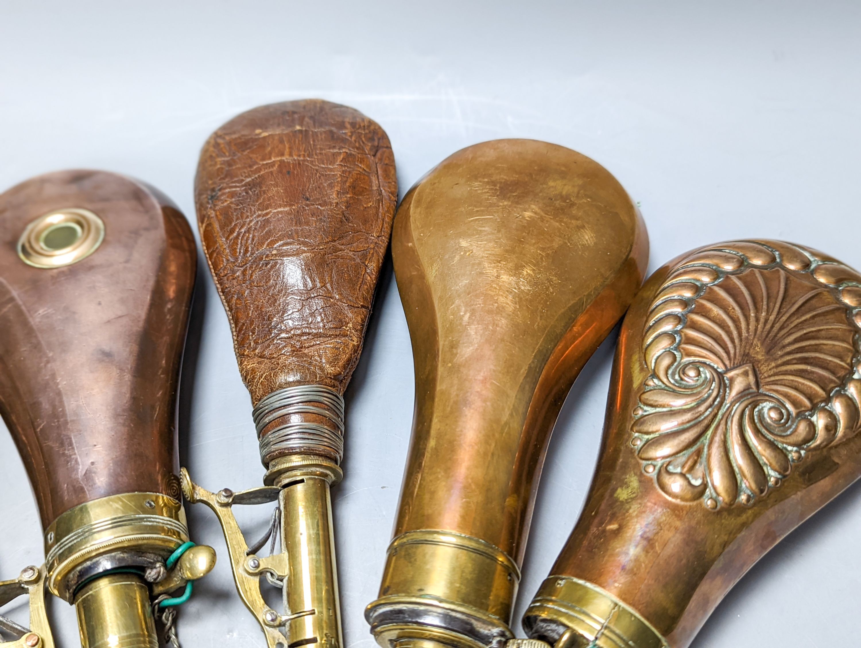 Six powder/shot flasks, 4 copper and brass, 2 leather and brass, together with a carved powder horn (7)
